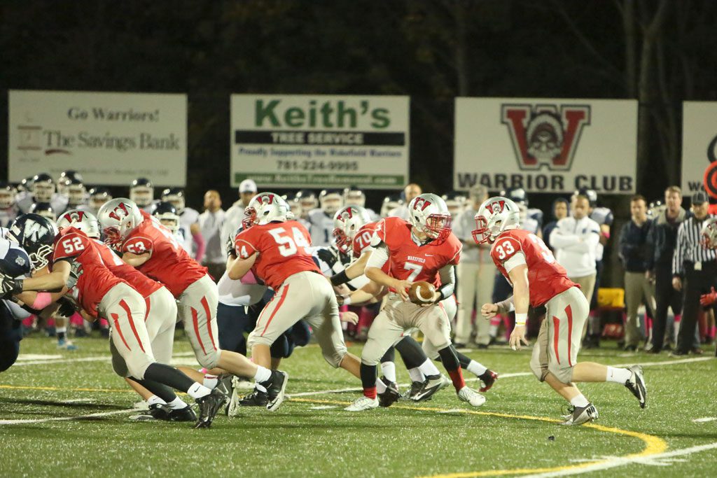 JUNIOR RB Zach Kane (#33) gets ready to receive the handoff from QB Anthony Cecere (#7) as several linemen Ben Joly (#70), Pat Boyson (#54), Matt Mercurio (#53) and Brian Conroy (#52) block for the running back. Kane scored a touchdown as the Warriors rolled to a 21-0 triumph Friday night at Landrigan Field. (Donna Larsson Photo)