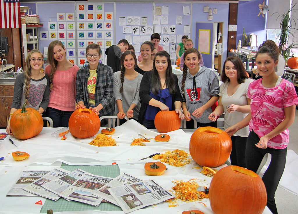 WAKEFIELD MEMORIAL HIGH SCHOOL Art students are preparing for the annual Carved Pumpkin Display as part of Fright Night. The carved jack o’ lantern display is on the steps of the Lucius Beebe Library Thursday, Oct. 30 from 6 to 8 p.m. From the left are Art students Jen Smith, Brianna Nardone, Sam Cross, Taylor Messina, Alyssa Kirk, Alyssa Corso, Carly Holbrook and Laura Martin with the rest of the class in the background are in the beginning stages of carving their designs for Thursday night’s event.