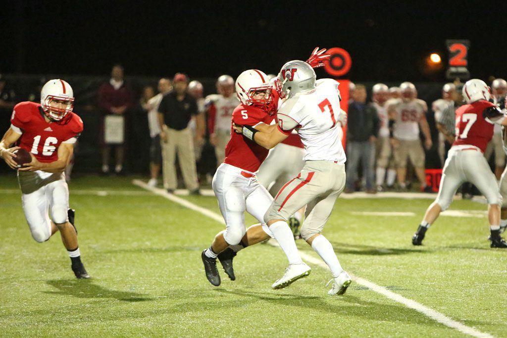 MELROSE'S MIKE Pedrini had four touchdowns for Melrose in their 42-21 win over Burlington last Thursday night on the road at Varsity field. Pedrini, pictured protecting Melrose quarterback Jake Karelas, has 7 touchdowns in two games, helping Melrose earn a 3-0 league record with Watertown on the horizon. (Donna Larsson photo) 