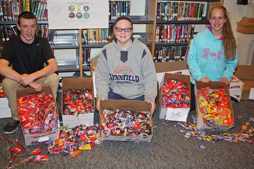 LYNNFIELD MIDDLE SCHOOL student council members, from left, Braden Doyle, Emily Dickey and Ashley Barrett proudly display the 10,000 pieces of candy collected as part of LMS’ fourth annual annual Sweets for Soldiers candy drive on Nov. 12. The candy will be donated to Operation Troop Support in Danvers, who will ship the candy to American troops serving overseas. (Dan Tomasello Photo) 