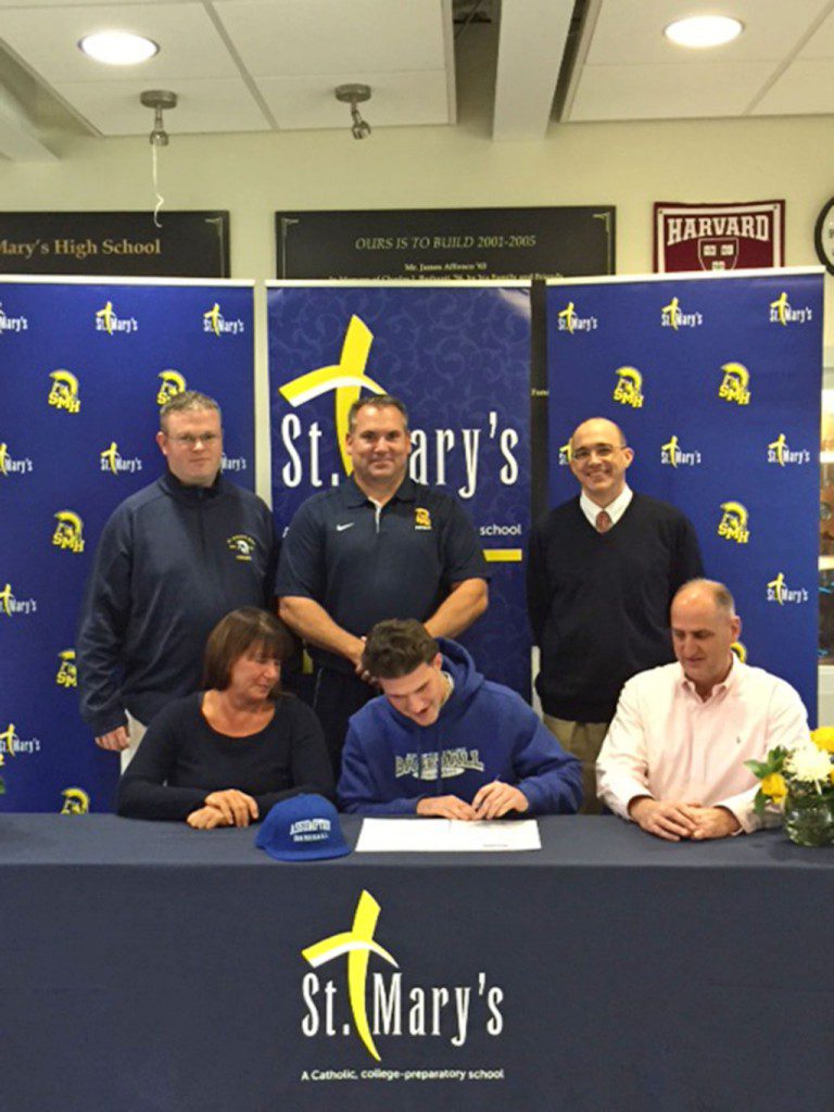 WAKEFIELD RESIDENT Clay Yianacopolus (front row, center) signed his letter of intent to attend Assumption College as his parents, Valerie and Glenn, are on the left and right of the St. Mary’s senior. In the back row (from left to right) are Athletic Director Jeff Newhall, Coach Derek Dana and Principal Mark DiFabio.