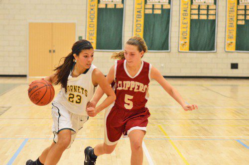 STEP FOR STEP. Hornet sophomore Katerina Hassapis brings the ball past her Newburyport defender as the Lady Hornets won the first varsity basketball game played in the new high school gymnasium, 55 to 50. (Bob Turosz Photo)