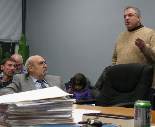 FRED LEVITAN (seated, left) of Carabetta Management Co. listens as tenant Jack Reggio relates his complaints about Colonial Point Apartments at 95 Audubon Rd. In the foreground is a stack of Health Department files on Colonial Point Apartments covering the last decade.
