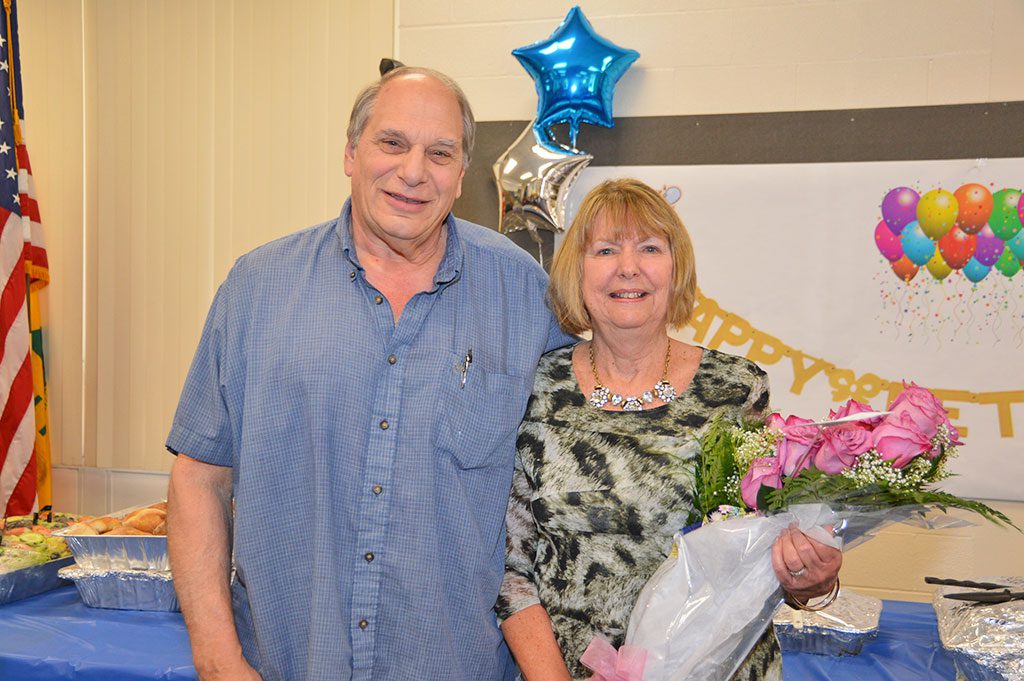 MICHELE MAWN, administrative assistant in the town's building was honored at a retirement party that included her family members and coworkers, including Building Inspector Jim DeCola. Mawn helped the building department run smoothly for 27 years and worked with four building inspectors. (Bob Turosz Photo)