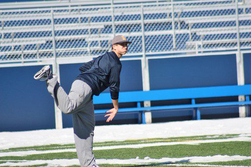 SOPHOMORE Kyle Hawes warms up his arm on the stadium field at LHS. Nearly all sports in the CAL have had an extended preseason due to snowy field conditions throughout the league. (Maureen Doherty Photo)