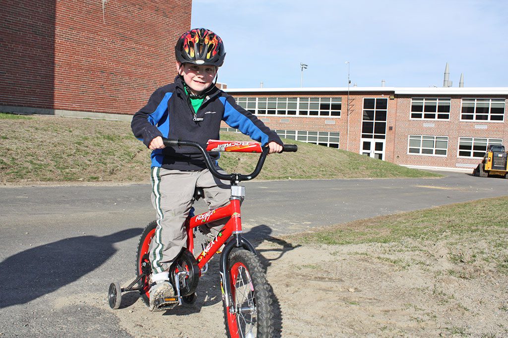 PRESCHOOLER Lucas Wilkinson, 4 1/2, had a blast riding his red BMX-style Rocket bicycle on the hilly pathways around the new softball and baseball fields at the high school last week. (Maureen Doherty Photo)