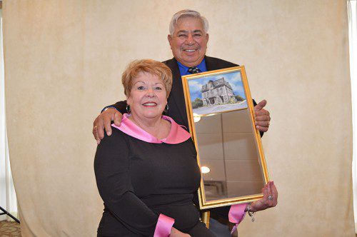 CITIZEN OF THE YEAR. Chuck Carucci and his wife Marianne at the Reading–North Reading Chamber of Commerce's Outstanding Citizens Awards Dinner. The mirror with an illustration of Flint Memorial Hall was a gift to Carucci from the Chamber. (Bob Turosz Photo)