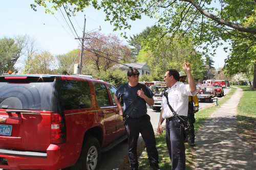 LYNNFIELD Fire Captain Michael Feinberg (right) gives instructions to a Saugus fire official from the Heritage Lane staging area during the height of the May 6 brush fire. Firefighters from nine area towns plus the state Forestry Fire Service assisted Lynnfield. (Maureen Doherty Photo)