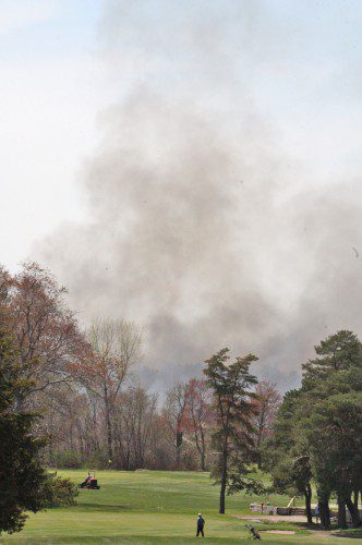 GOLFERS at the Reedy Meadow Golf Course continued to play their rounds last Wednesday while smoke from the five-alarm brush fire burned in the distance. (Maureen Doherty Photo)