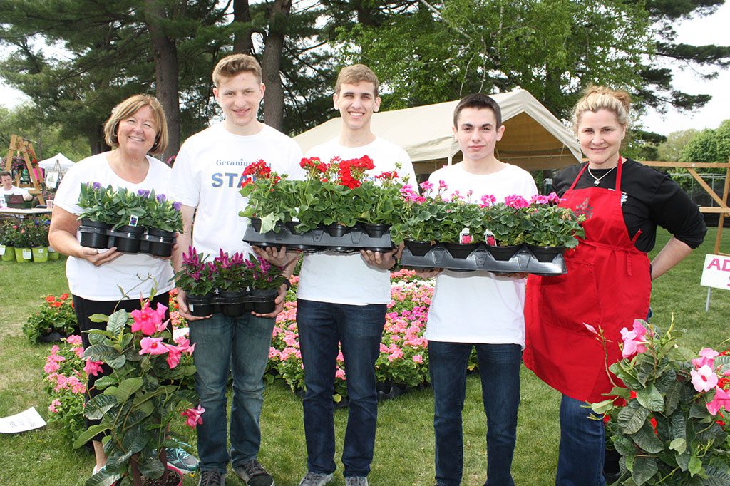 TOWNSCAPE'S revitalized GeraniumFest, combined with new Field Day activities at the middle school, was a phenomenal success on Saturday with hundreds in attendance. Shown with a sampling of the wide variety of flowers sold this year in addition to traditional geraniums are (from left): Townscape member Joan Bourque, LHS senior volunteers Gabe Landau, Matthew Parziale and Nick Fabrizio and Townscape member Paula Parziale. (Maureen Doherty Photo)