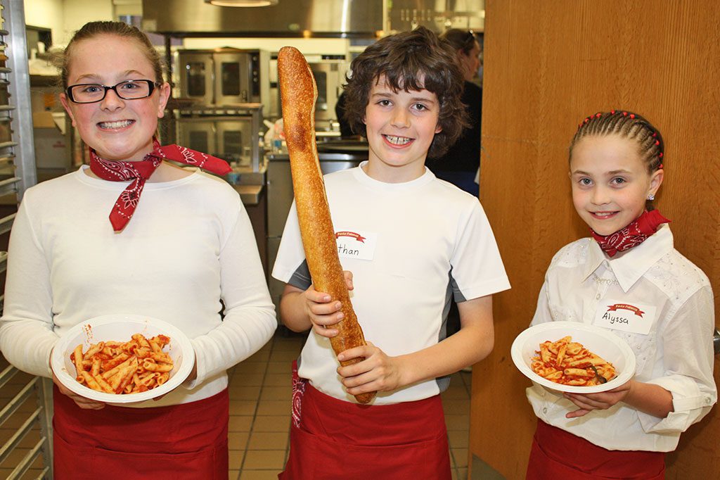 SUMMER STREET SCHOOL students, from left, Maggie Ozanian, Nathan Lopez and Alyssa O’Keefe served local residents delicious pasta dishes and tasty bread during the Pasta Palooza family dinner, hosted by the Summer Street School PTO, on Wednesday, April 29 at Lynnfield High School. The pasta was donated by Countryside Deli and the bread was donated by Panera. (Dan Tomasello Photo)  