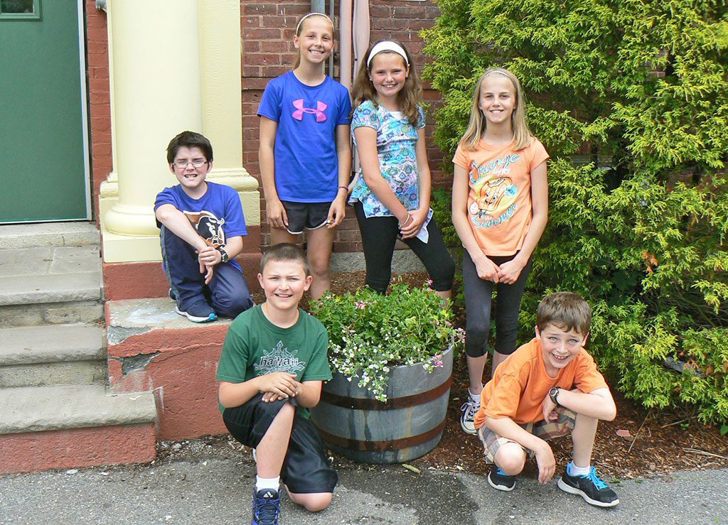 THE GREENWOOD SCHOOL 4th Grade Student Council was busy getting their flowering whiskey barrels ready for summer! Council members are Ryan Carroll, Spencer Little, Summer Milksy, Jillian Schwartzberg, Molly Berinato and Evan Zeltsar. On Tuesday, June 16, they removed all the pansies and prepared the barrels for the pink ivy geraniums and snowflake. They learned how to remove the plants from their containers. Also they learned that placing the plant in different positions in the barrel creates a different look for those walking by the barrels. Deadheading the geraniums was their next step so that the new shoots will grow. They planted the snowflake in the front of each barrel so that it will cascade down as the season progresses. Last step was watering and feeding the plants. Capone Landscape donated the plants and assisted the children with this activity.