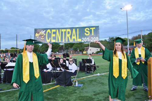 THE GIFT OF DIRECTIONS. Class Treasurer Cole Hughes and Vice President Jackie Lanzaro aloft part of the Class of 2015’s gift to the high school at commencement Friday night – street signs so visitors can find their way in the new school. This is an enlarged version. At right is class president Matthew Stead. (Bob Turosz Photo)