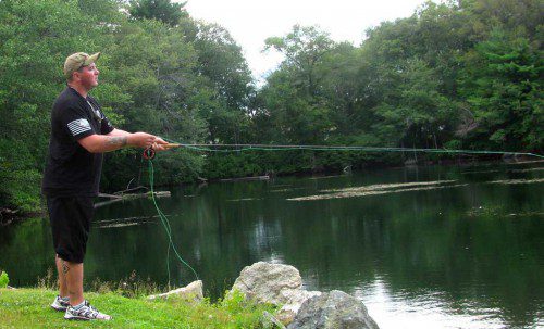 GREG FOWLE of Woburn, an Iraq War combat veteran, casts his line in Patkin Pond behind the Malden Anglers Club in Saugus at last Wednesday evening's Project Healing Waters Fly Fishing program.