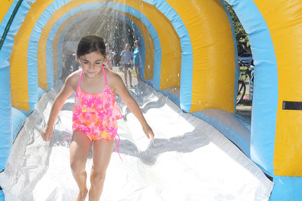 RECREATION STATION CAMPER Gianna Micieli had a great time running through the cooling spray of the inflatable Slip 'n Slide at the Summer Street School playground recently. (Dan Tomasello Photo)