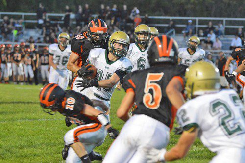 HORNET MATT MCCARTHY (center), fights his way through the Ipswich Tiger defense prior to breaking free to score North Reading's first touchdown of the season on the team's first possession of the game. (Bob Turosz Photo)