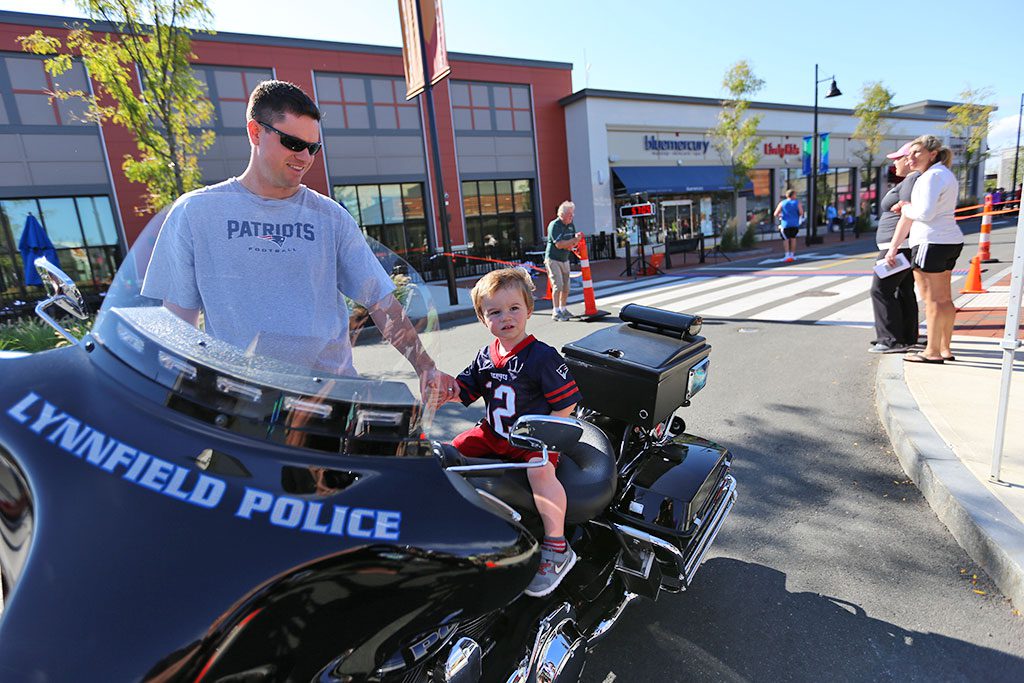 LYNNFIELD HIGH SCHOOL Assistant Principal Kevin Cyr and his young son Brian check out the police department’s motorcycle after the Best Buddies Friendship 5K at MarketStreet Lynnfied on Sept. 20. The high school will be launching a Best Buddies chapter next month. (Courtesy Photo)
