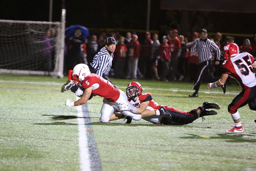 GOOD LUCK trying to get Melrose's Mike Pedrini out of the end zone. The junior running back scored four touchdowns for the Red Raider football team, who improved to 4-0 after a 28-7 victory over Watertown last Friday at Fred Green Field. (Donna Larsson photo)