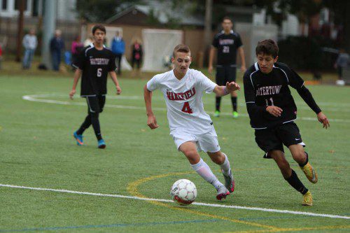 DAN KERRIGAN, a sophomore (#4), dribbles the ball by a Watertown defender. Kerrigan assisted on one of the four goals as the Warrior boys’ soccer team blasted the Red Raiders by a 4-1 score yesterday afternoon at Walton Field. (Donna Larsson Photo)