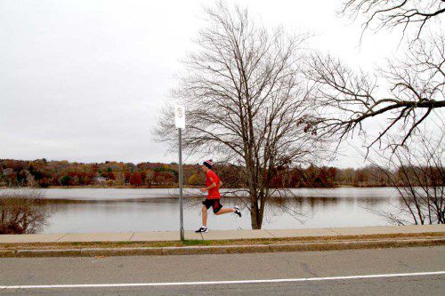 A RUNNER does his part to brighten an otherwise dreary day on Lake Quannapowitt recently. (Donna Larsson Photo)