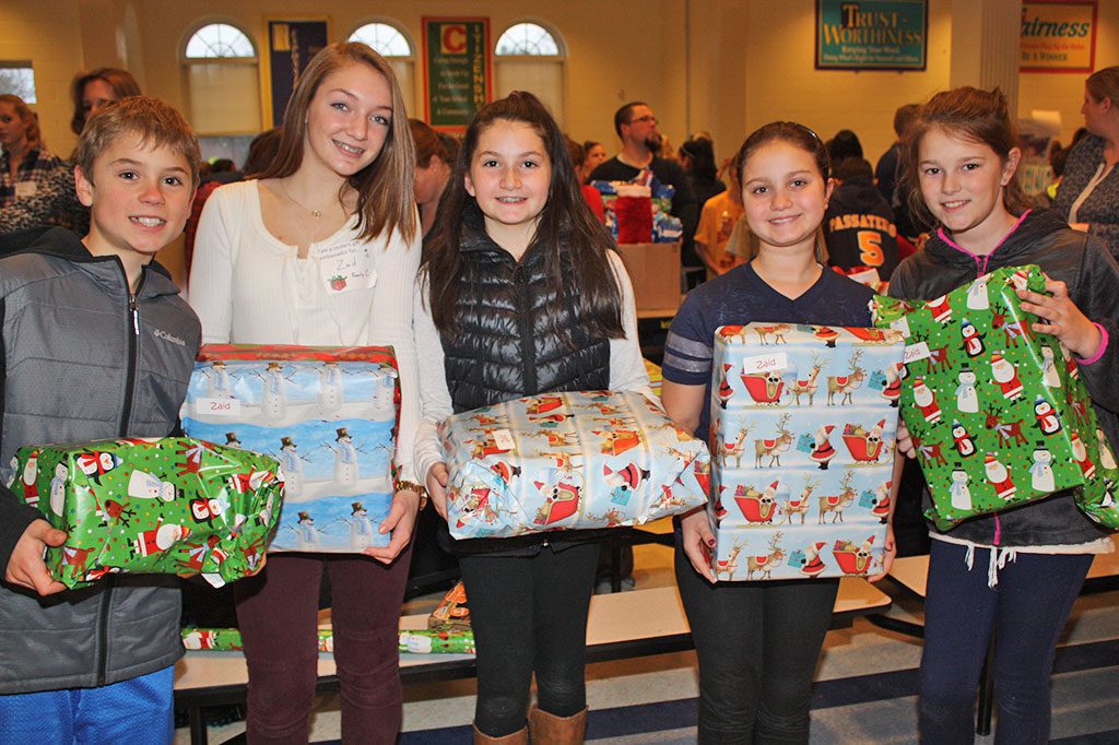SANTA’S LITTLE HELPERS, from left, John McKrell, Maddie Burke, Cassie Giordano, Genna Gioioso and Skylar Furey proudly display wrapped presents during Lynnfield Middle School’s annual holiday gift drive Dec. 18. The LMS community donated over 1,000 gifts to needy families this year.  (Dan Tomasello Photo)