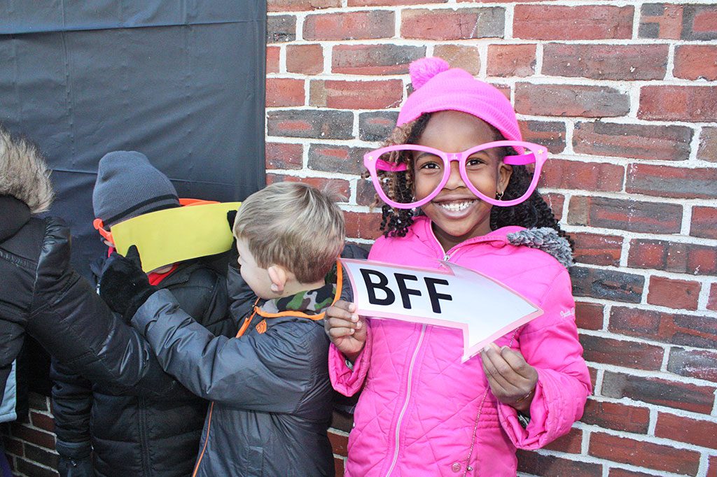 KINDERGARTNER Jolly Adetule has fun using the oversized props at the photo booth station while posing for her class picture during the Huckleberry Hill School's annual walk-a-thon. She is a student in Ms. Emily Bonnano's class. (Maureen Doherty Photo)