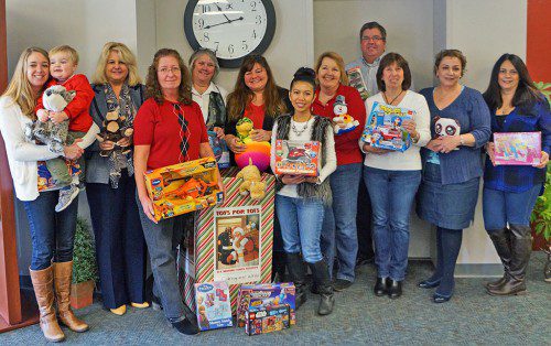 WAKEFIELD CO-OPERATIVE BANK recently held its annual holiday toy drive to benefit Toys for Tots at its 342 Main St., Wakefield, and 596 Main St., Lynnfield offices. The bank ended up collecting approximately 300 toys between Thanksgiving and Christmas Eve with the help of staff, local residents and businesses and Summer Street Elementary School in Lynnfield. U.S. Marine Corps Reserve ‘Toys for Tots’ program was established in 1995 as a means of providing gifts to less fortunate youngsters during the holiday season every year. Pictured here are employees at the bank’s 342 Main St. office participating in a recent Jeans Day, where staff was invited to wear jeans to work in exchange for a donation to purchase toys for the drive. Seen left to right: Jennie Terry (with son Finn), Marketing; Theresa Carson, Business Development Manager; Rose Krepps, Assistant Branch Manager and Toys for Tots drive coordinator; Lois Hayward, VP Retail Operations/IT; Carol Sacco, IT Specialist; Raya Cheth, Commercial Loan Assistant; Jane Coonrod, Executive Assistant; Michael Wolnik, President & CEO; Joyce Grasso, VP, Human Resources; Judy Cianciarulo, VP, Lending Administration; Lisa DiGregorio, AVP, Loan Services.