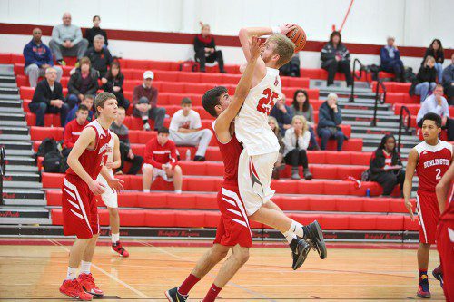 SENIOR CENTER Andrew Auld (#25) goes up for a shot over Burlington’s Fernando Lamin in Wakefield’s 51-43 triumph at the Charbonneau Field House. Auld scored 21 points and had 15 rebounds in the victory. (Donna Larsson Photo)
