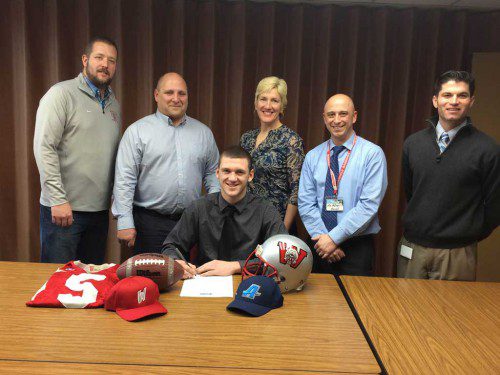 SENIOR Tighe Beck (front) recently signed his letter of intent to attend Assumption College where he will play football. In the back row (from left to right) are Warrior football coach Steve Cummings, Peter Beck (Tighe’s father), Bernadette Farrell (Tighe’s mother), WMHS Principal Richard Metropolis and Brendan Kent, K-12 Director of Athletics, Health, and Wellness for the Wakefield Public Schools.