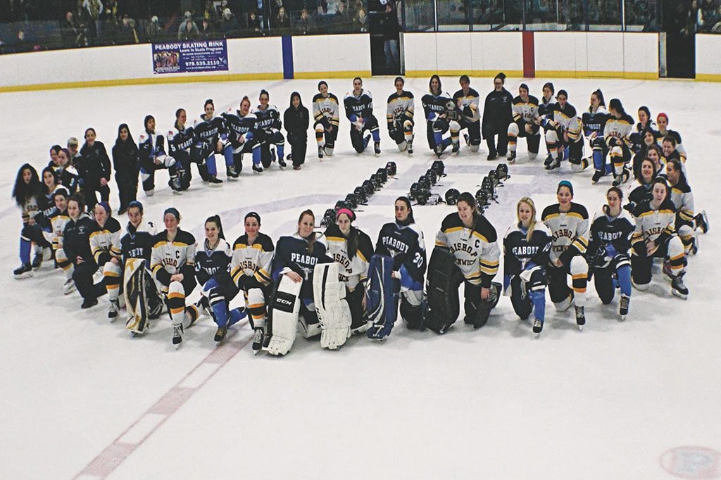 IN A SHOW of camaraderie prior to the inaugural Peabody Cup girls’ varsity hockey tournament, the Peabody/Lynnfield/North Reading co-op and Bishop Fenwick came together at center ice to recognize Boston Pride player Denna Laing of the National Women’s Hockey League. Laing is recovering from a severe spinal cord injury. Raffles sold at the tourney raised $400 for the Denna Laing Fund. (Mark Grant Photo)