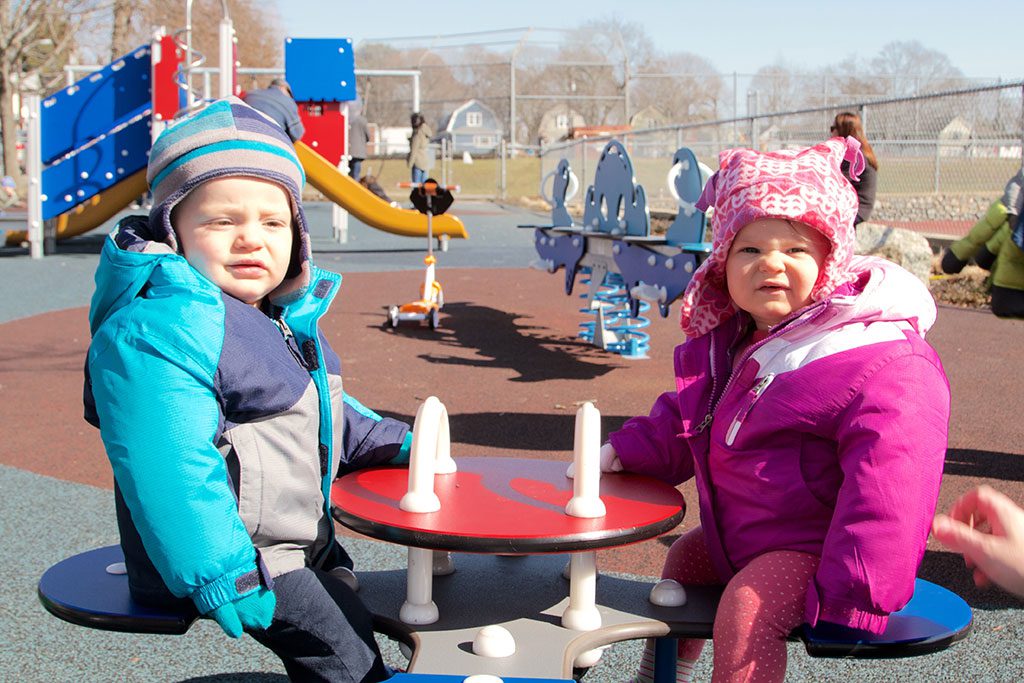 TWINS Kent (left) and Caroline Eckart-White, age 11 months, take a moment to relax at the Commons playground last Sunday while enjoying the mild temperatures. (Donna Larsson Photo)