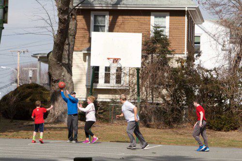 A group of residents played a pickup basketball game at JJ Round Park while enjoying mild temperatures on Sunday. (Donna Larsson Photo)