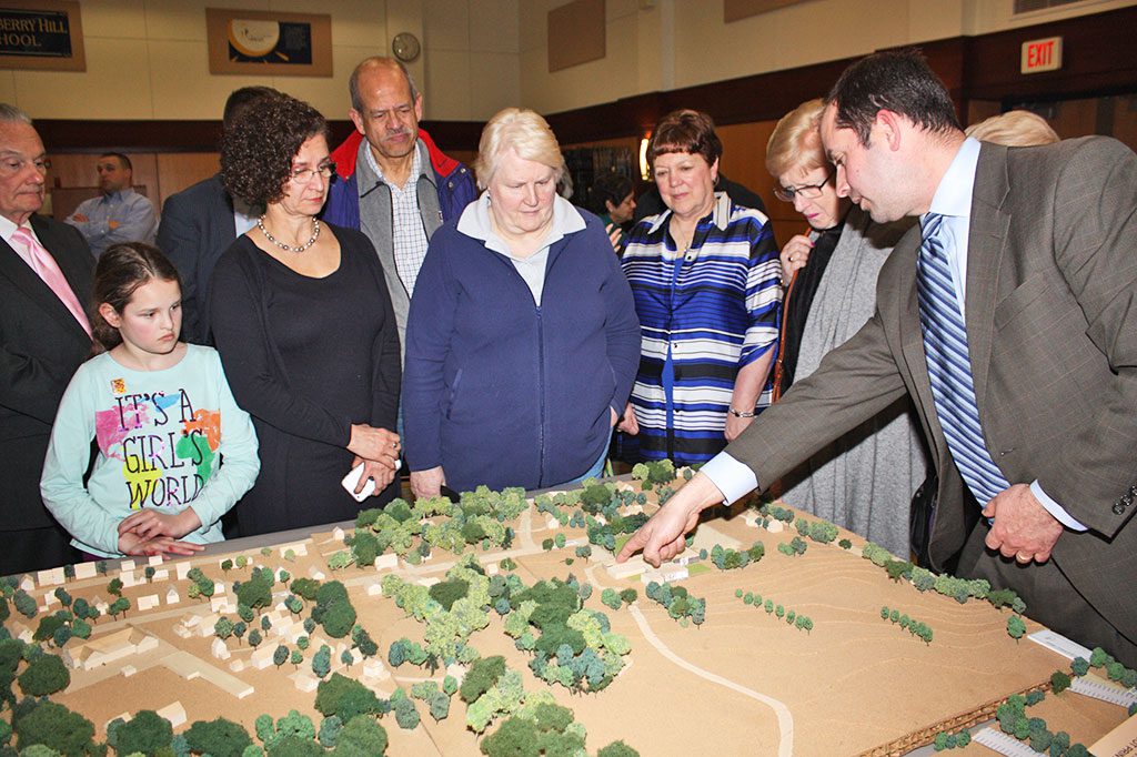 ARCHITECT Kevin Bergeron (at right) points out the changes made to the proposed library building at Reedy Meadow on the scale model of the town center to those gathered at the third community forum hosted by the Library Building Committee. (Maureen Doherty Photo)