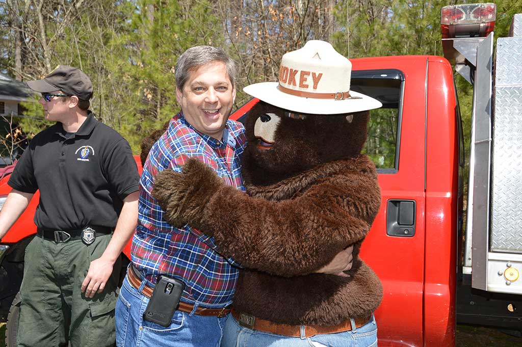 BEAR HUG. State Senator Bruce Tarr, who represents North Reading, was thrilled to meet Smokey the Bear at the 100th anniversary celebration for Harold Parker State Forest on Saturday. (Bob Turosz Photo)