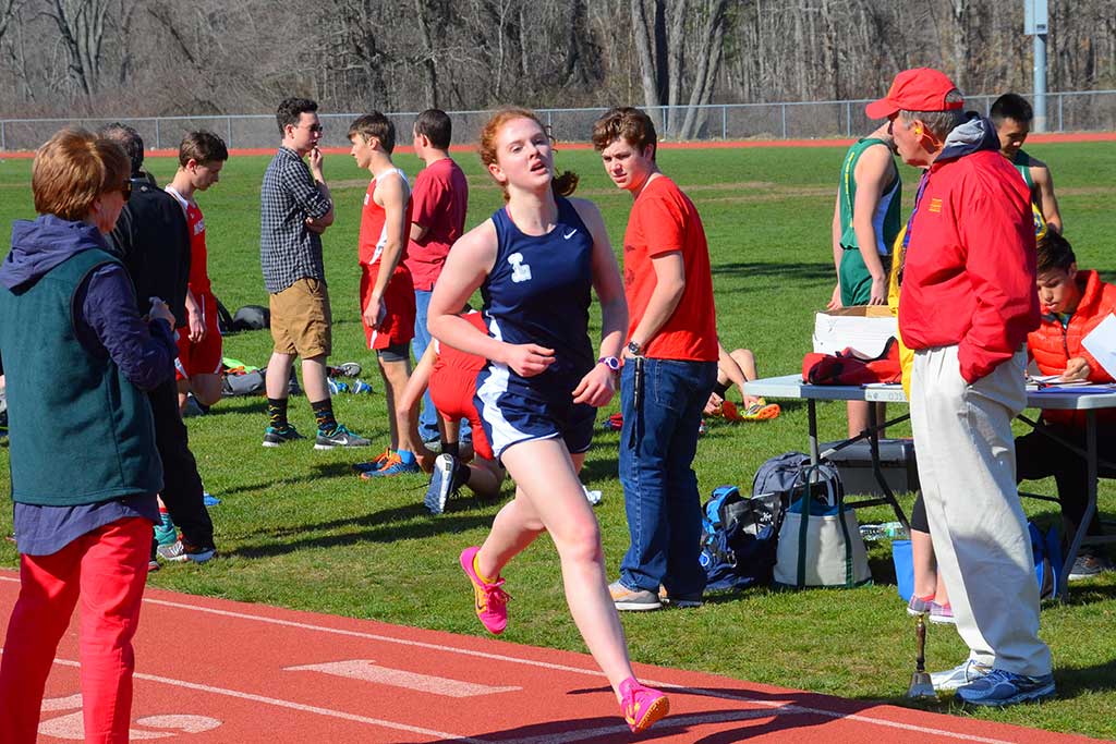 SENIOR captain Abby Norwood crosses the finish line in the mile in 5:43 at the first tri-meet of the season. She won the race against Masconomet and took second against North Reading. (John Friberg Photo)