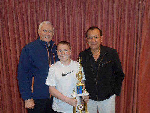 KNIGHTS OF COLUMBUS 14-year-old State champ Lucas Smith holds his championship trophy as he is congratulated by Free Throw chairman Bob Curran (left) and Grand Knight Vinny Gonzales.