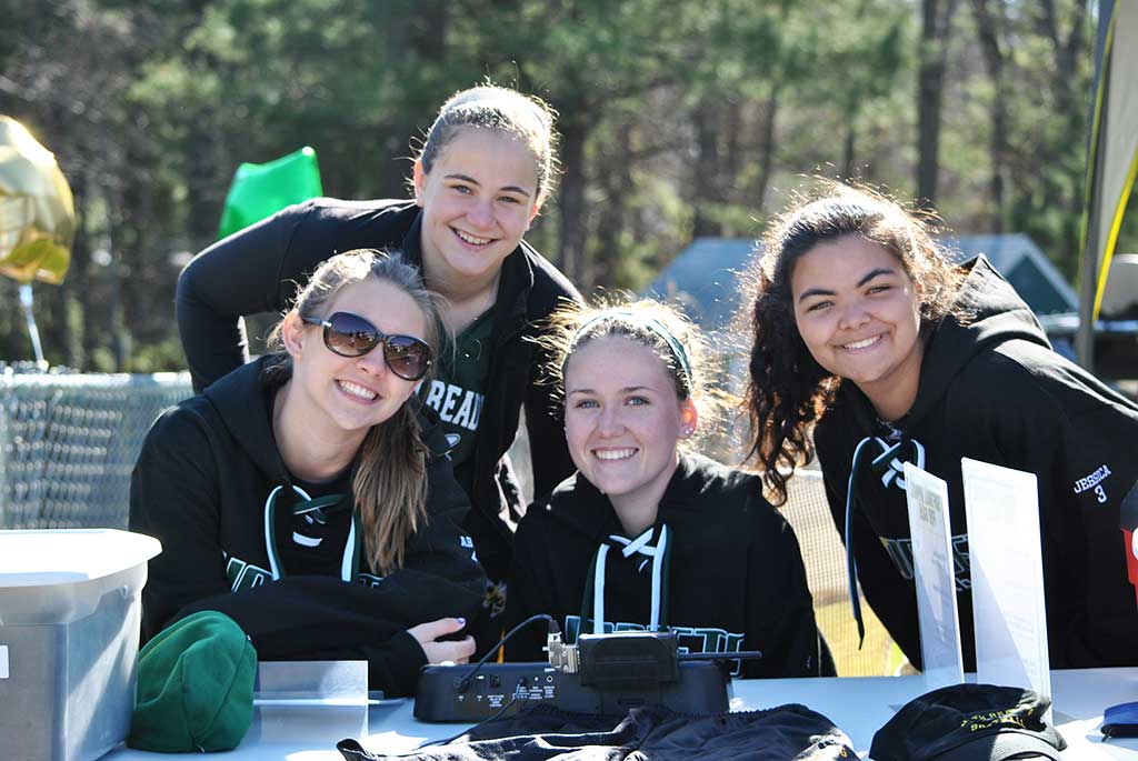 GRADUATES of the North Reading Girls Softball Program came back to help out and cheer on friends at Opening Day.  (From left: Abby Carroll, Maggie Majeski, Hailey Sanphy and Jess Ferrazzani). (Courtesy Photo)