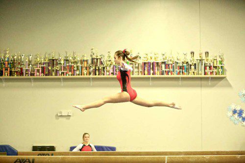 MYA MARSHALL leaps on beam for the MHS gymnastic team, off to 2-0 this season after wins over Burlington and Wakefield. (Donna Larsson photo)
