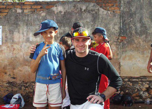 North Reading resident Mike Driscoll, a senior at Northeastern, posed during a recent visit to Cuba with a young baseball fan sporting his newly-acquired Boston Red Sox hat. Read more about the visit in this week’s sports section. (Courtesy Photo)