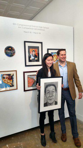 LYNNFIELD HIGH SCHOOL sophomore Zoe Chen proudly displays her grand prize winning drawing Roots along with Congressman Seth Moulton during the Sixth Congressional District High School Art Competition at Montserrat College of Art recently. (Courtesy Photo)