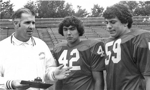 BOB BISACRE, JR., a former WMHS head football coach, instructs two of his captains during the 1975 football season. Bisacre passed away on Wednesday, March 1 at the age of 79. (Item File Photo)