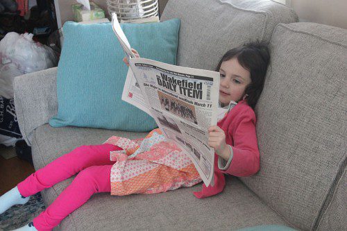 WHILE WAITING FOR HER father to come do the Sudoku puzzle with her, Hannah Huskey decided to catch up on some local news. (Brooke Huskey Photo)