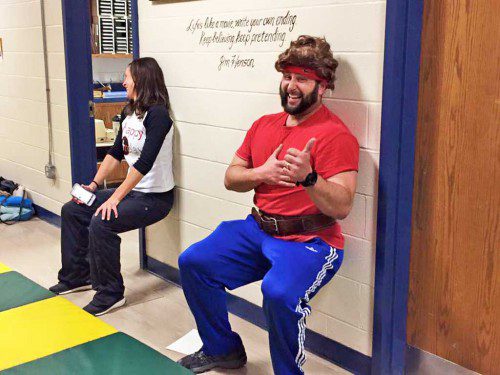 Fit Revolution owner Michelle O’Connor (left), joins physical education teacher Phil Nackley, for a few wall sits during the EE Little School’s annual Family Fitness Night last Wednesday. (Courtesy Photo)