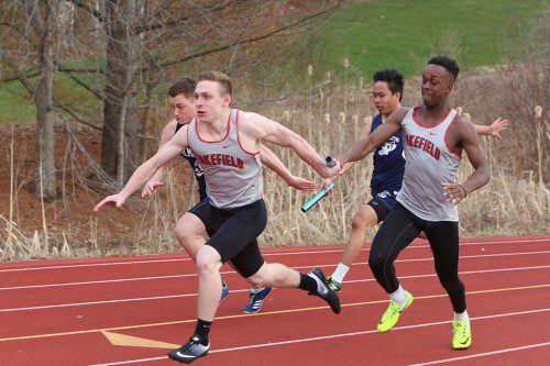 HENRY STIKEMAN (left) takes the baton on the handoff from Marc Biennestin (right) during the 4x100 relay. The Warriors won the relay in a time of 45.7 seconds. Also running the relay were Dan Sallade and Joe Carmilla-Smith. (Donna Larsson Photo)