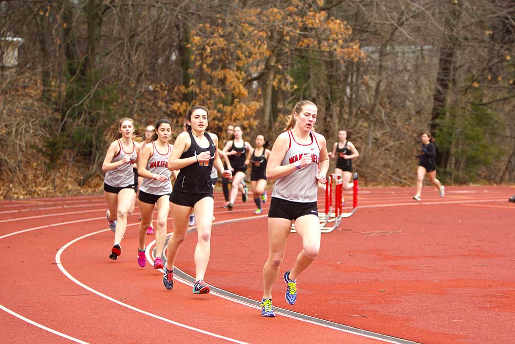 GILLIAN RUSSELL, a junior (right), leads the pack of runners in Wakefield’s scrimmage meet against Woburn last week. Russell took third in the mile against Stoneham with a time of 6:04.3 in the season opener on Monday at SHS. (Donna Larsson File Photo)