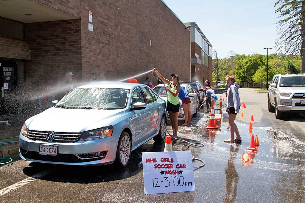 THE GIRLS’ SOCCER team worked diligently to clean residents’ cars during its car wash fundraiser recently. (Donna Larsson Photo)