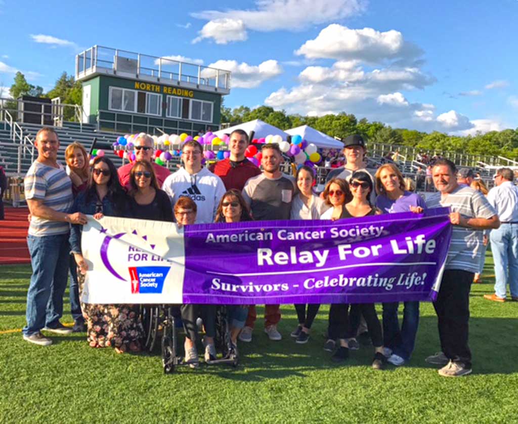 The annual North Reading Relay for Life drew a sizable turnout last Friday at the high school track, with walkers spending the evening raising thousands of dollars to fight cancer. Shown from left to right: Richard DiGiantommaso, cancer survivor speaker Joyce DiGiantommaso, Joyce’s daughter Jamie Ryan, Donna Sartell, Dayna Sartell, Mark Moran Jr., Kevin O’Toole Jr, Pauline Uccello, Shannon Fisher, Mark Moran, Donna Coskren, (back row) Kevin O’Toole Sr., Daniel O’Toole, Jack Moran, kneeling in front (mother Louise Moran) and sister Christine O’Toole. (Courtesy Photo)