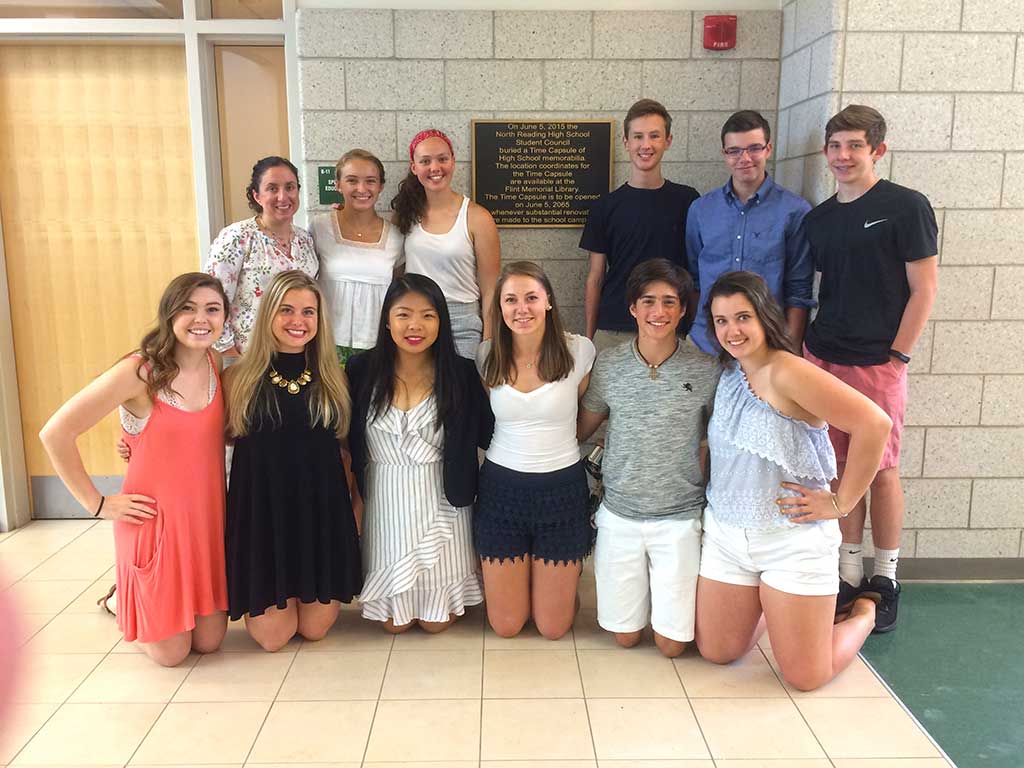 NRHS students, joined by some recent graduates, show off the new hallway plaque commemorating a time capsule expected to be opened in the mid-2060s. (Bill Laforme photo)