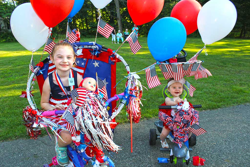 THE McKANAS SISTERS, Lily, 5 (left) and Ella, 7 months, were awarded a Top 5 prize for their uniquely designed patriotic decorated bicycle and tricycle in Lynnfield Rec's annual Horribles Parade held July 5 to celebrate Independence Day. (Maureen Doherty Photo)