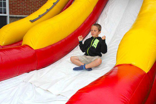 MATTHEW CHAMPY channels his inner Buddha while riding the inflatable slide at Recreation Station July 19. (Dan Tomasello Photo)